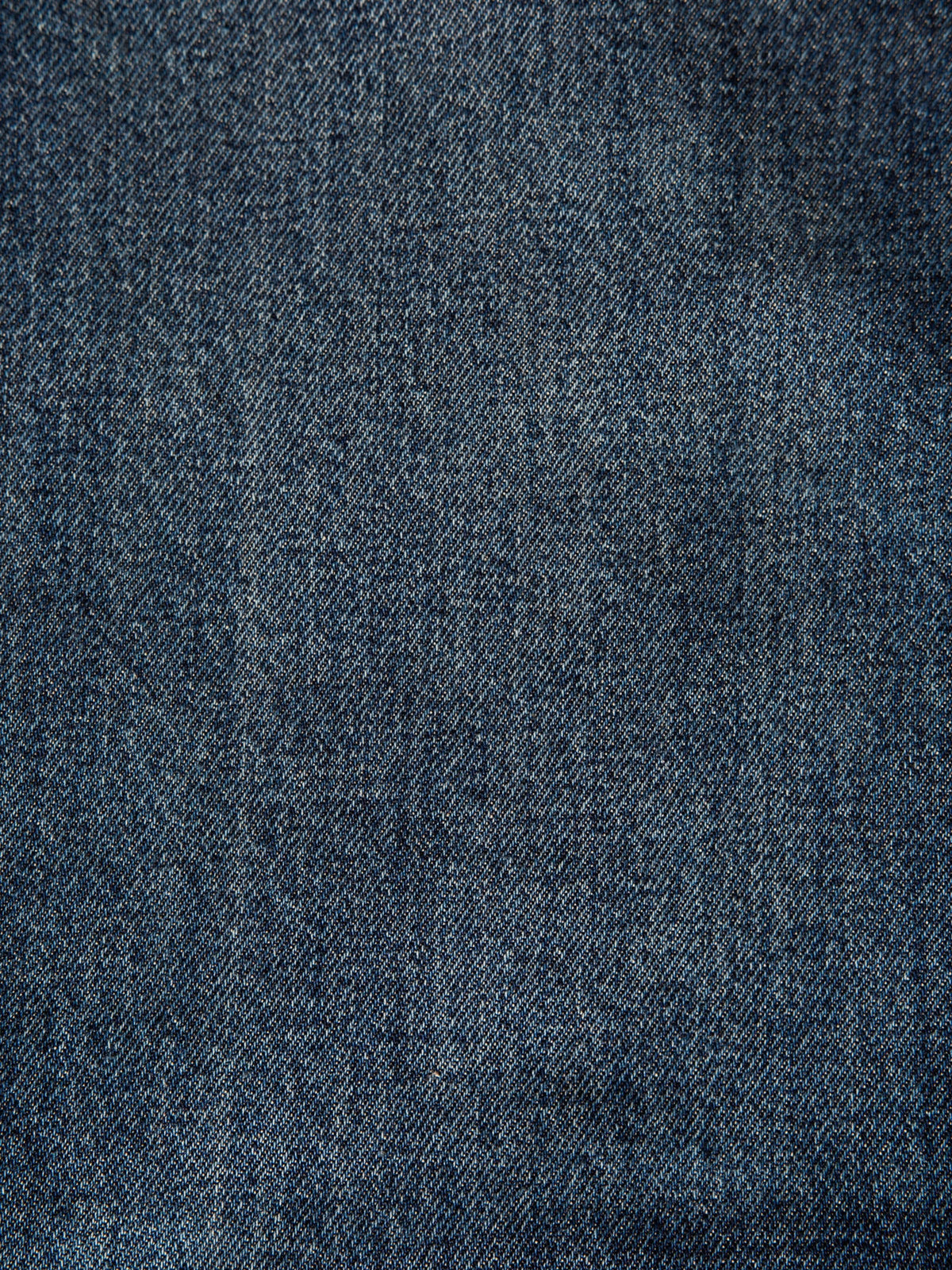 Nudie Jeans Steady Eddie II Blue Soil, a close-up of the dark blue wash rigid denim fabric.