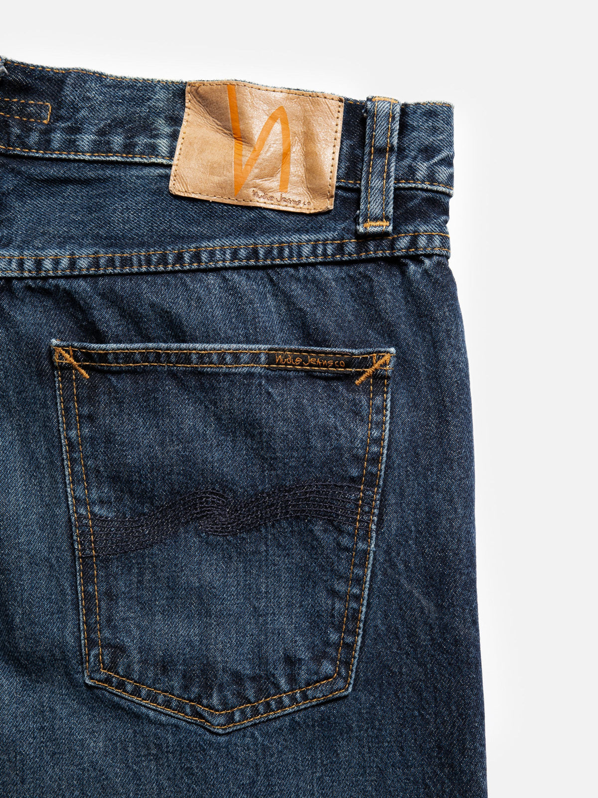 Nudie Jeans Steady Eddie II Blue Soil, close-up of the back showing the jacron patch and back pocket with navy embroidery.