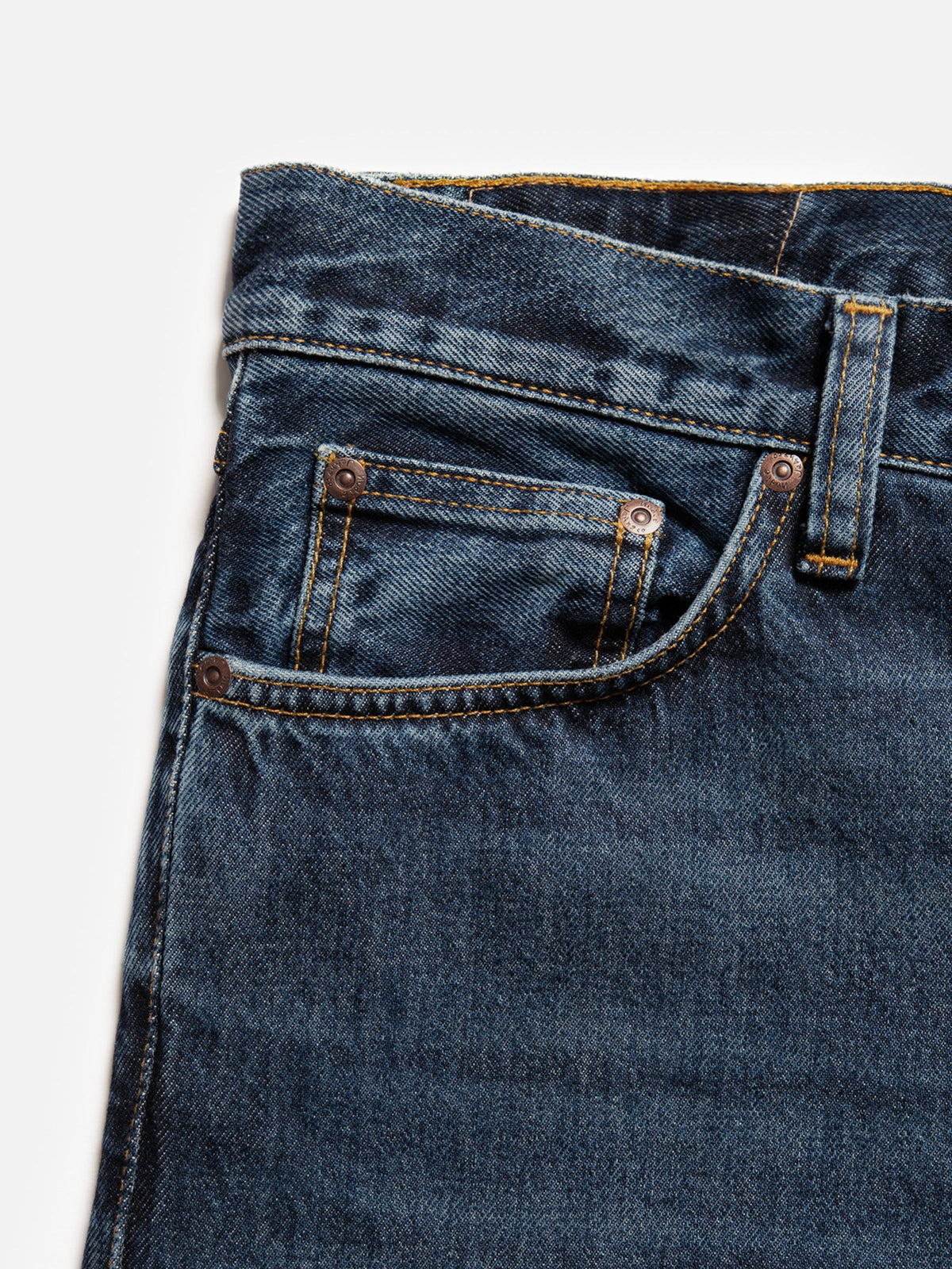Nudie Jeans Steady Eddie II Blue Soil, close-up of the front pocket detailing the tobacco stitching and copper rivets.