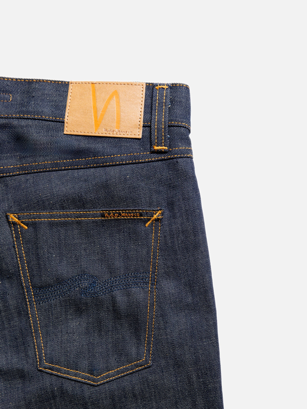 Nudie Jeans Gritty Jackson Dry Old, close-up of the back showing the jacron patch and indigo back pocket embroidery.