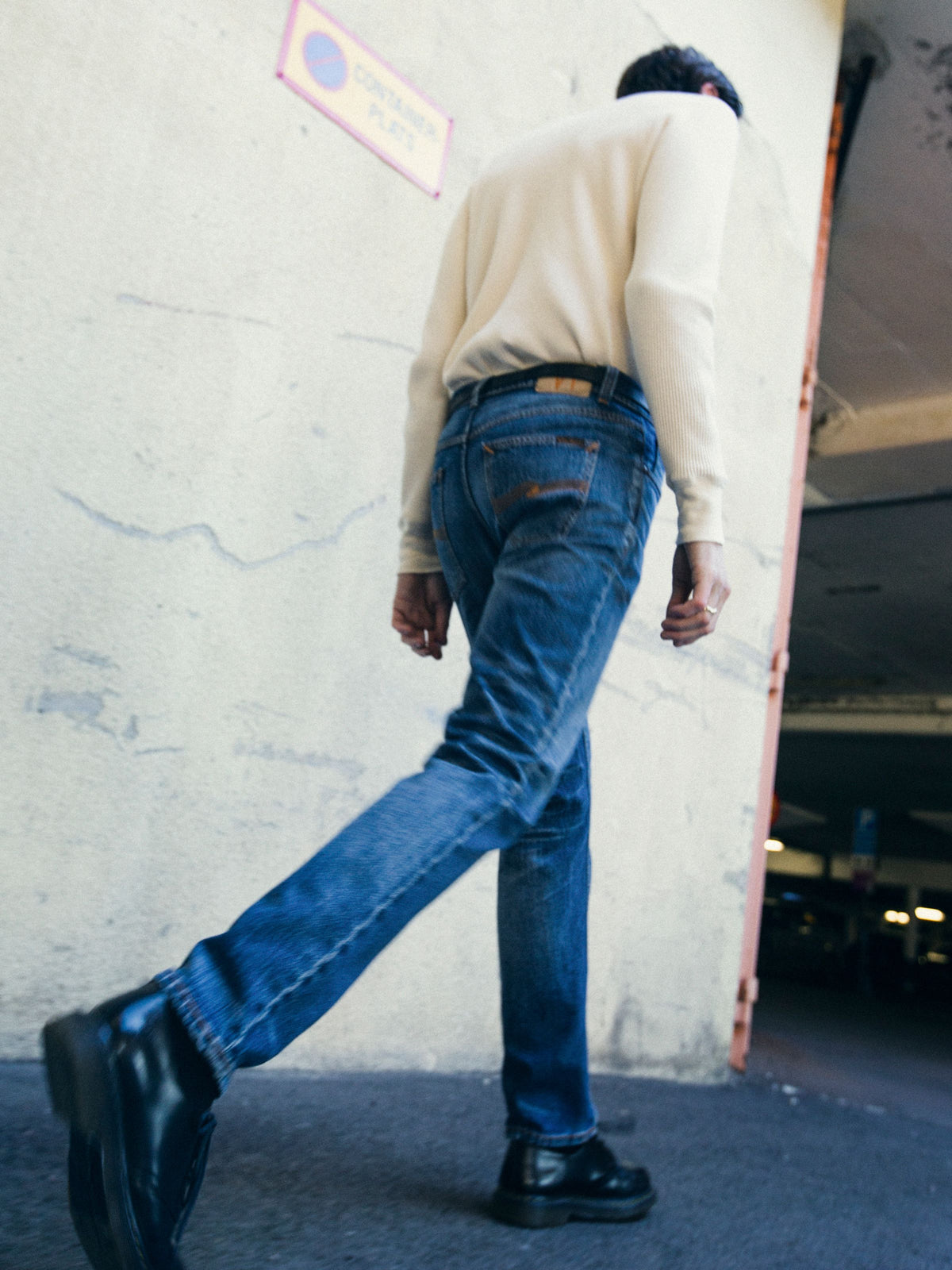 Nudie Jeans Solid Ollie Life Tracks, men's slim fit jeans in a mid-blue wash, shown from behind on a model walking.