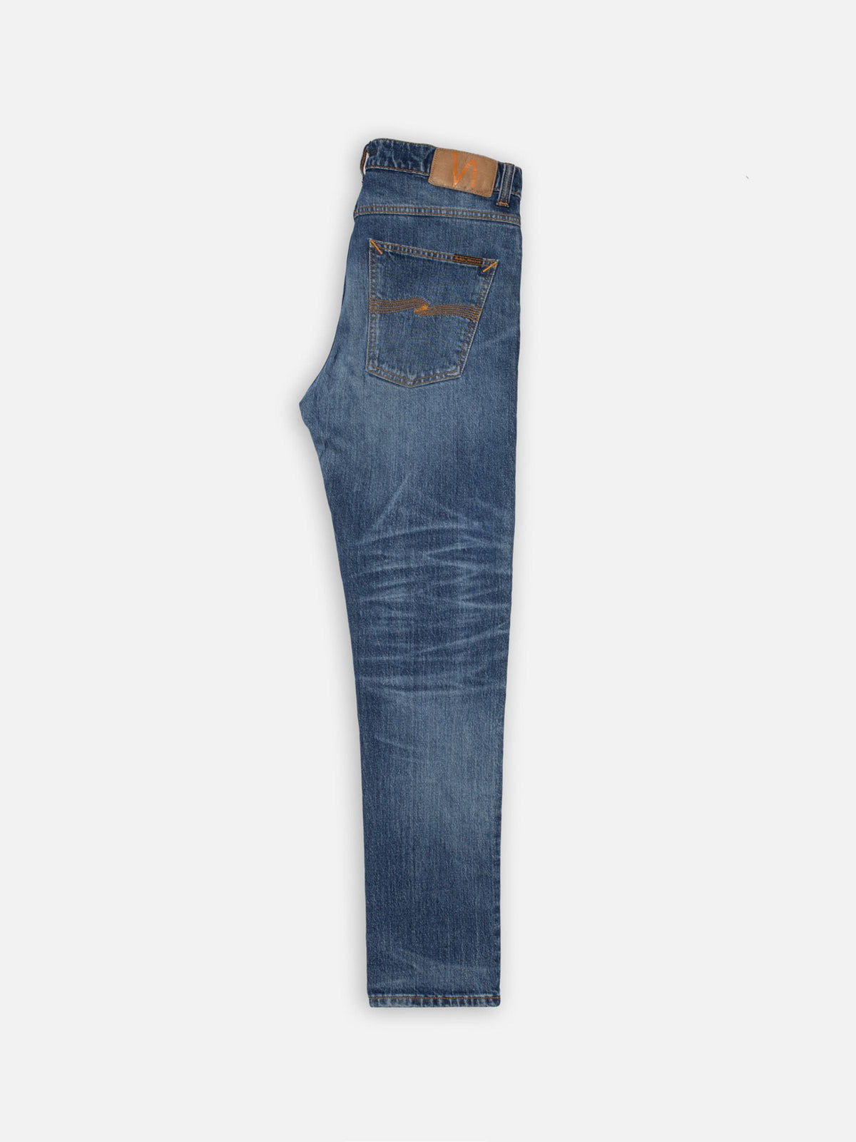 Nudie Jeans Solid Ollie Life Tracks, men's slim fit jeans in a mid blue wash, laid flat and folded to show the side profile.