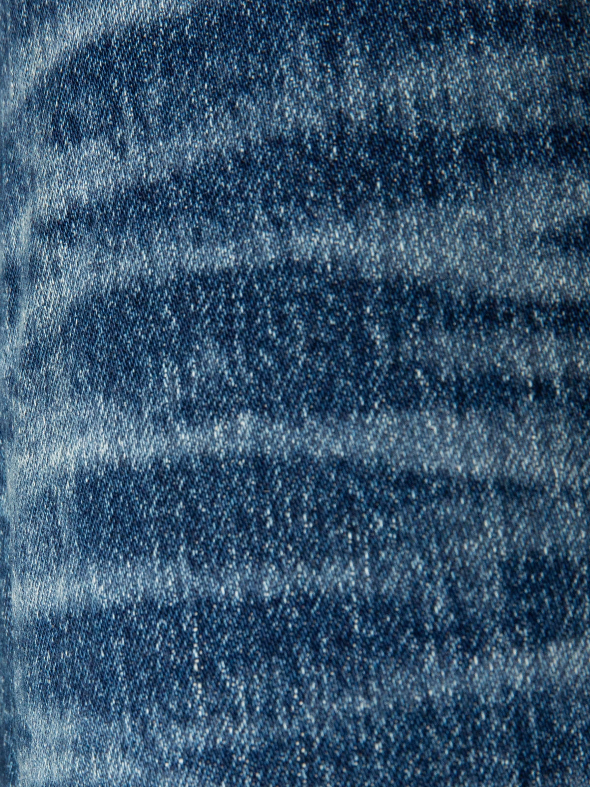 Nudie Jeans Solid Ollie Life Tracks, a close-up of the washed dark blue stretch denim showing the fabric's texture and fades.