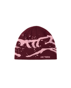 Maroon beanie with pink design and Arc'teryx logo on a beige background