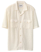 A white short-sleeved button-up shirt with floral lace pattern, featuring a camp collar and two chest pockets.